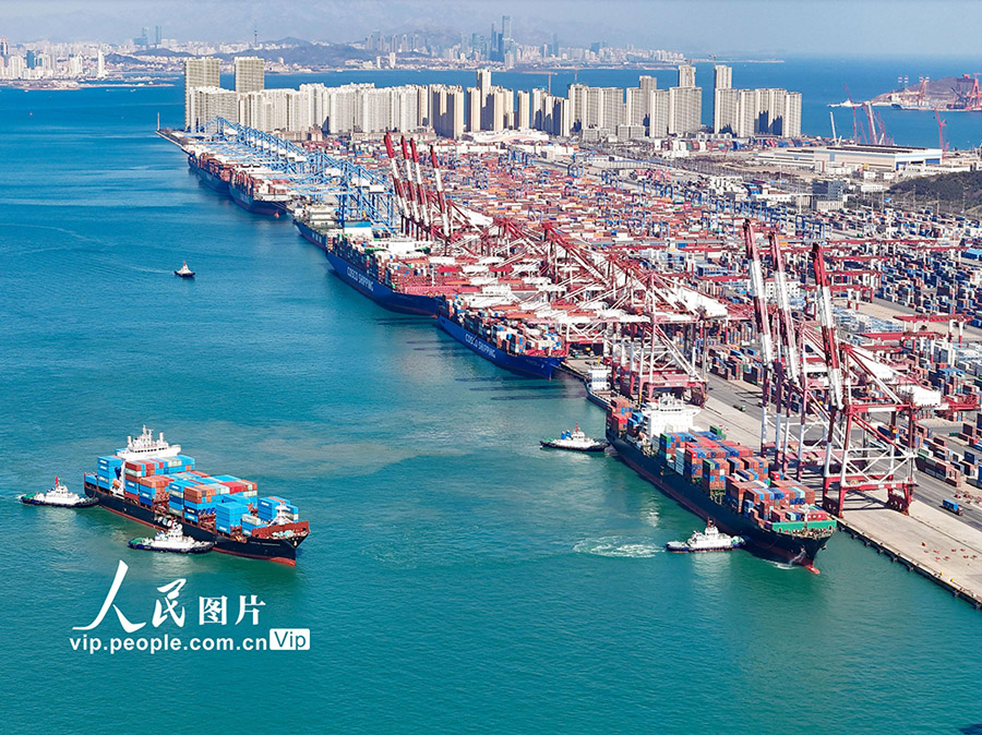 数十隻の貨物船が埠頭に停泊し、貨物の積み下ろしを行う山東省青島港の活気ある光景（3月20日撮影・張進剛/写真著作権は人民図片が所有のため転載禁止）。