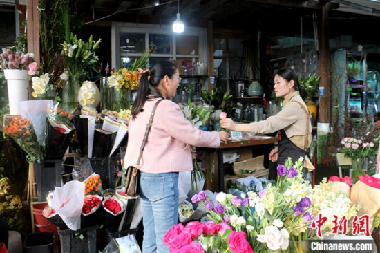 安徽省合肥市の花屋で花を買う女性（3月23日撮影・張強）。