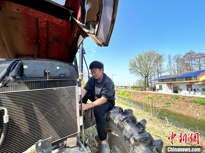 3月28日、自宅のエビ養殖水田で農業機械の点検整備を進めている00後（2000年代生まれ）の虢宇さん。（撮影・曹盈）