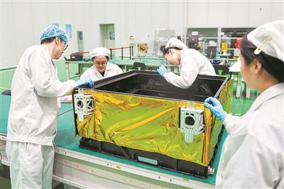製造を終えた多層断熱モジュールで衛星の外殻を覆う呉清爽氏（左から2人目）とチームのメンバー（4月2日撮影）。撮影・許暢