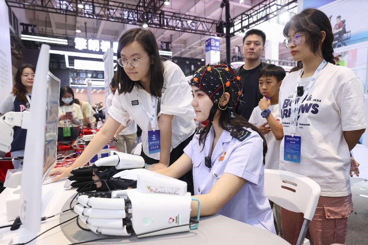 2023年8月21日、北京で行われた2023世界ロボット博覧会で、人工知能マルチモーダルBMIプラットフォームを体験する女性。撮影・陳暁根/人民図片