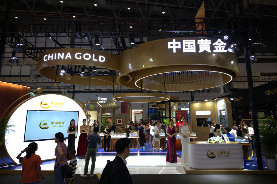 宝飾品展示エリアと「世界中で売買」エリアに設置された中国の黄金展示ブースを見学する来場者（4月13日撮影・翁奇羽）。