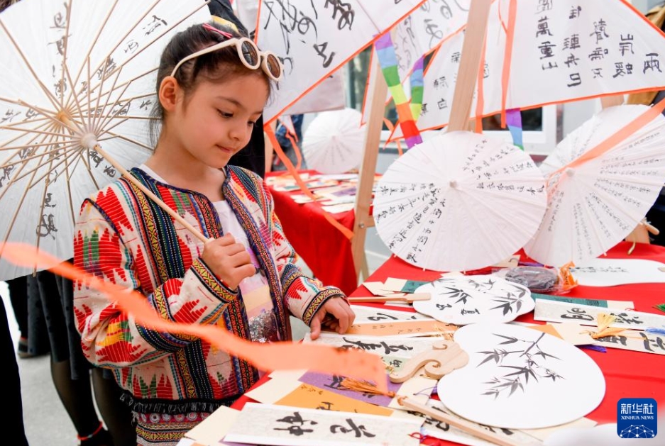 烏魯木斉市天山区南湾街街道（エリア）で、展示されている「穀雨」をテーマとした作品を見学する子供（4月16日撮影・王菲）。