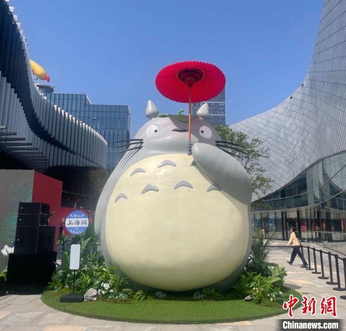 高さ6メートルのトトロ。中国蘇州風の赤い油紙を張った傘を差し、横のバス停の名前は「稲荷前」の代わりに「上海駅」になっている。（撮影・高凱）