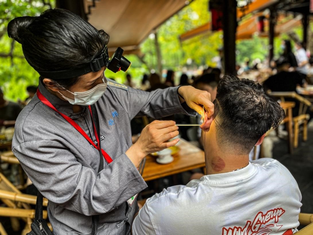 成都市人民公園内の鶴鳴茶社で耳掃除サービスを受ける客（撮影・羡江楠）。