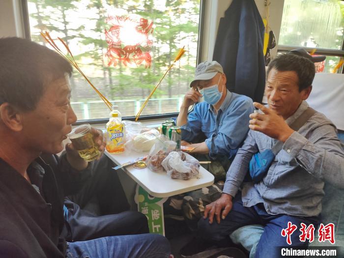車内でビールを飲みながら会話する男性たち（写真提供・中国鉄路哈爾浜局集団有限公司）。