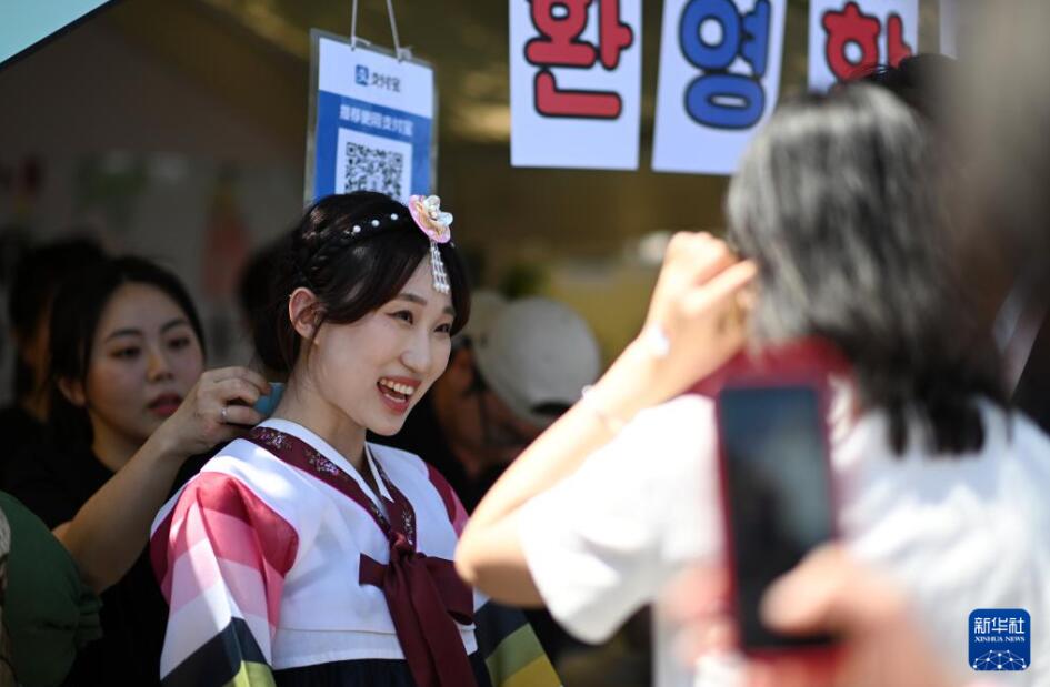 天津大学国際文化フェスティバルのブース前で来場者と交流する韓国人学生（5月12日撮影・趙子碩）。