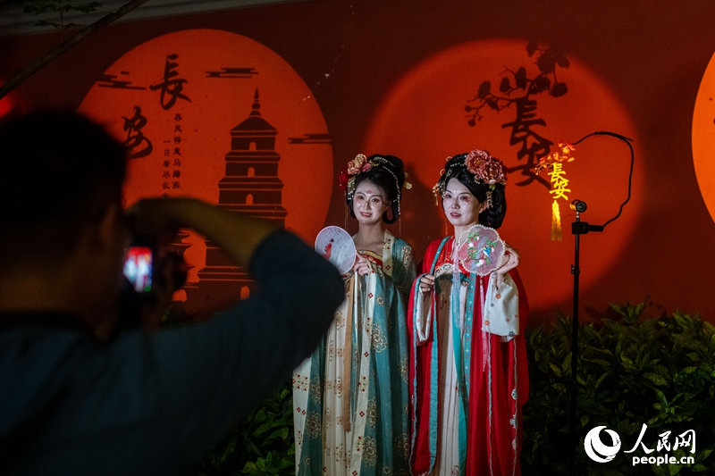 西安の「大唐不夜城」で、伝統衣装姿で写真撮影する女性たち（撮影・翁奇羽）。
