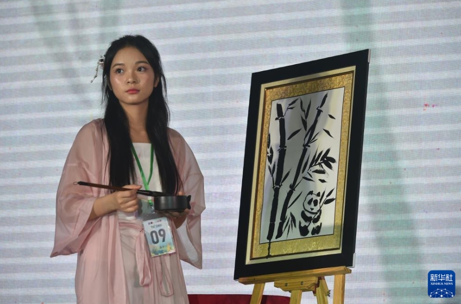 ベトナムのハノイで開かれた第23回「漢語橋」世界大学生中国語コンテストのベトナム北部・中部地区決勝大会で、水墨画を披露するハノイ師範大学の大学生（5月25日撮影・胡佳麗）。