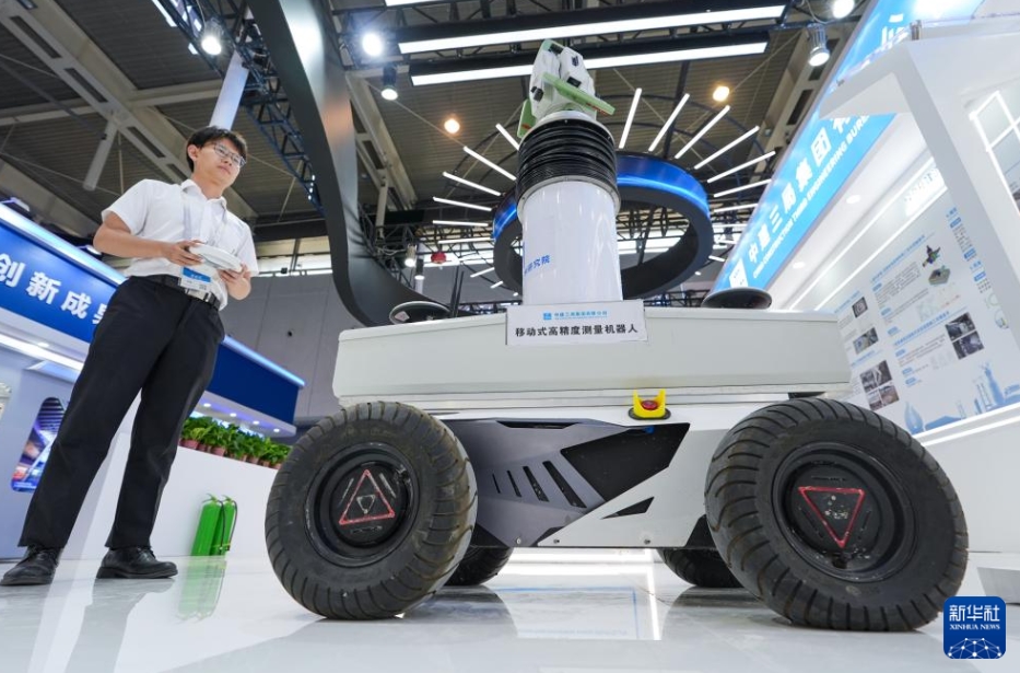 中建三局集団有限公司のブースで、「移動式高精度測量ロボット」を操作するスタッフ（6月13日撮影・李博）。