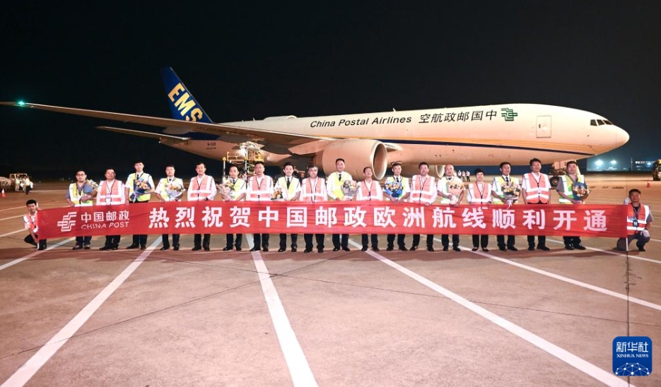離陸を控えた貨物専用機の前で集合写真を撮影する中国郵政航空の職員と乗務員（6月26日撮影・朱正義）。