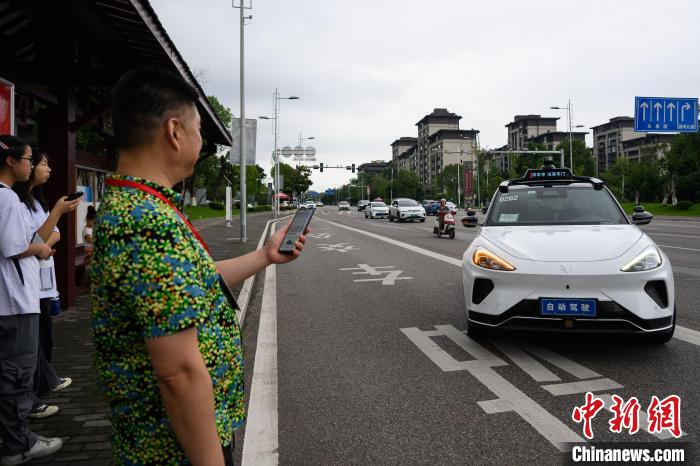 重慶市永川区の路上で、自動運転サービスを体験する海外華文メディアの代表（7月10日撮影・何蓬磊）。