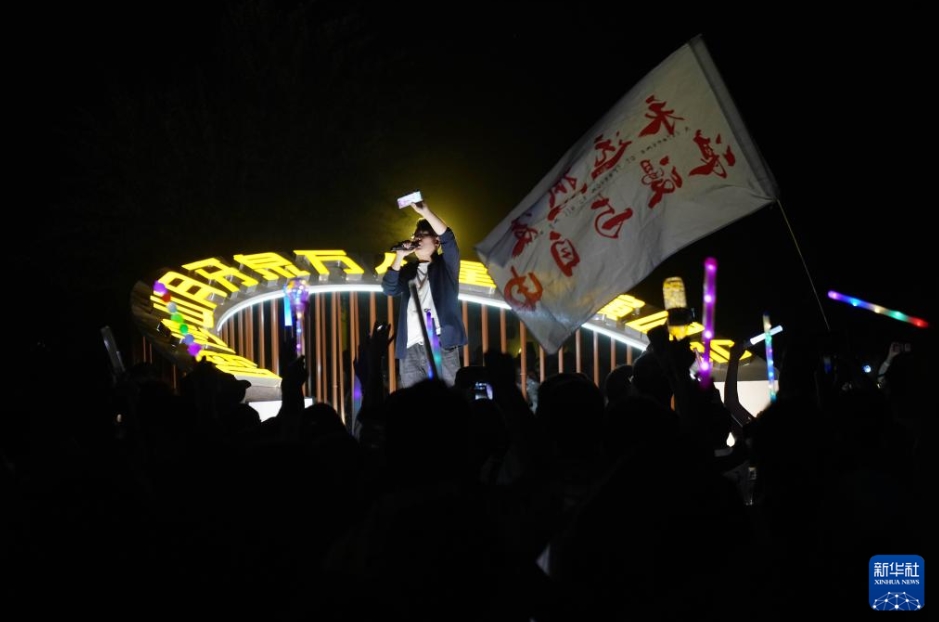 甘粛省敦煌にある鳴沙山月牙泉景勝地で開催された「万人星空コンサート」でステージに立ち、観客に一緒に歌うように呼び掛ける司会者（7月15日撮影・馬寧）。