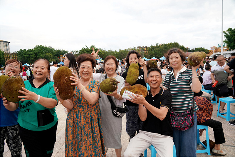 受け取ったパラミツを持って記念写真を撮影する市民や観光客（撮影・楊幫慶）。