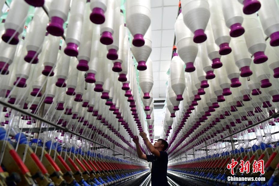 福州市長楽区にある福建金源紡績の5Gスマート工場の生産ラインで働く作業員（7月17日撮影・張斌）。
