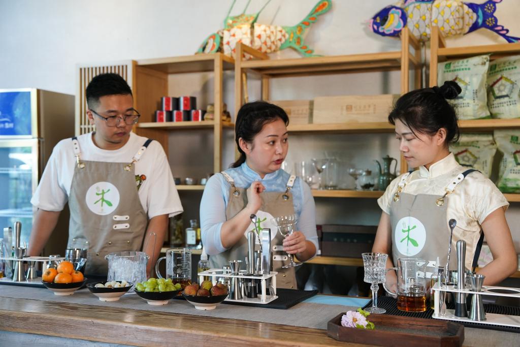 5月23日、学生に「新中国スタイルのティードリンク」の作り方を教える調飲師の汪蓀さん（写真中央）。