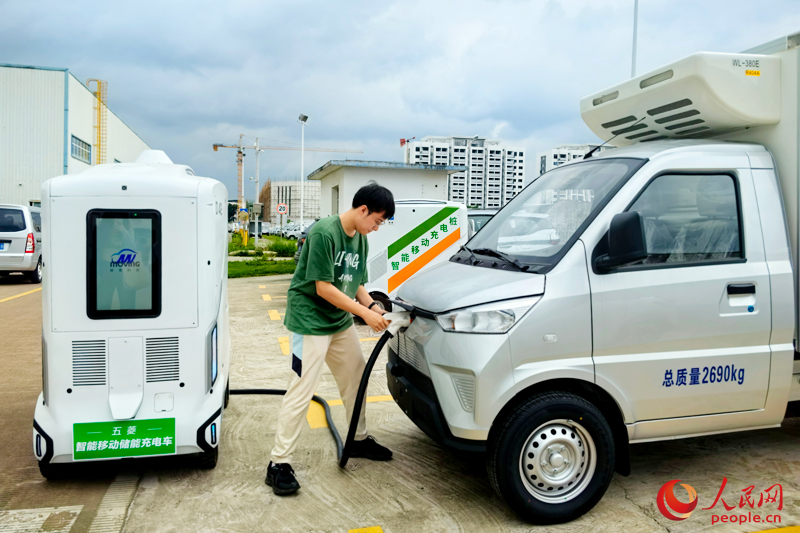 スマートモバイル蓄電・充電車を使い新エネルギー自動車の充電を行う作業員。撮影・付華周