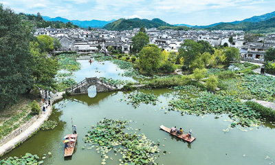 安徽省黄山市徽州区の古い村落が夏の観光シーズンを迎えた。写真は呈坎の古村の永興湖で筏に乗る観光客。（撮影・樊成柱。写真提供は人民図片）