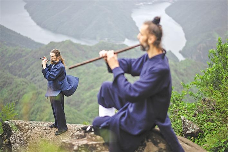 8月10日、十堰市の白馬山天馬峰の頂上で、中国の伝統楽器「洞簫」や「竹笛」の練習をするアイルランド人のエレンさん（写真左）とポーランド人のダリウスさん（写真右）。