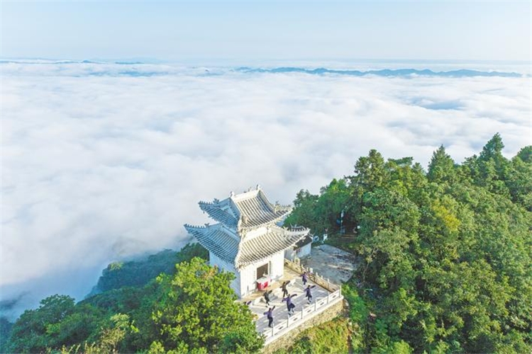 8月19日早朝、白馬山天馬峰の頂上で、朝日に向かってカンフーの練習をする外国人たち。