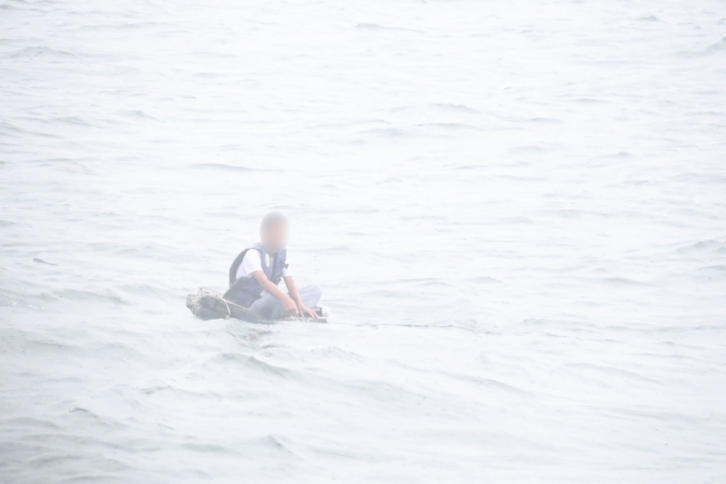 沿岸警備隊が発見した発泡スチロールの板に座ったまま海に流されていた男性(写真提供・広東海警局)。