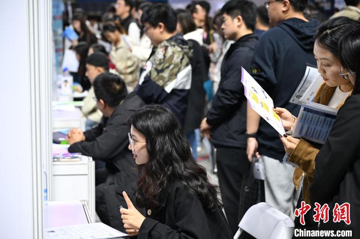 合同就職面接会で雇用機関に問い合わせをする大学生（撮影・田雨昊）。