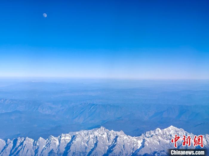 機内から撮影した月と玉竜雪山（写真右下、11月13日撮影・江飛波）。