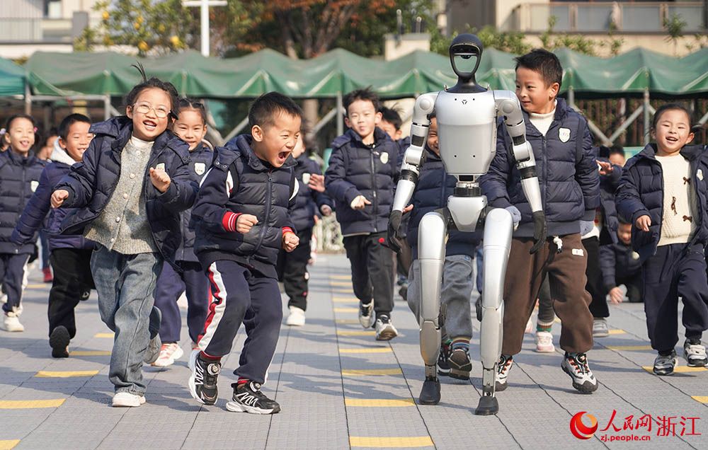 寧波市江北区の慈城懐之幼稚園で、園庭を走り回る園児と人型ロボット（撮影・章勇涛）。