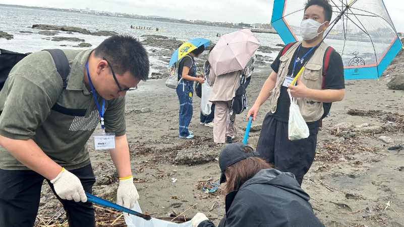 海岸清掃体験をする中日の若者たち