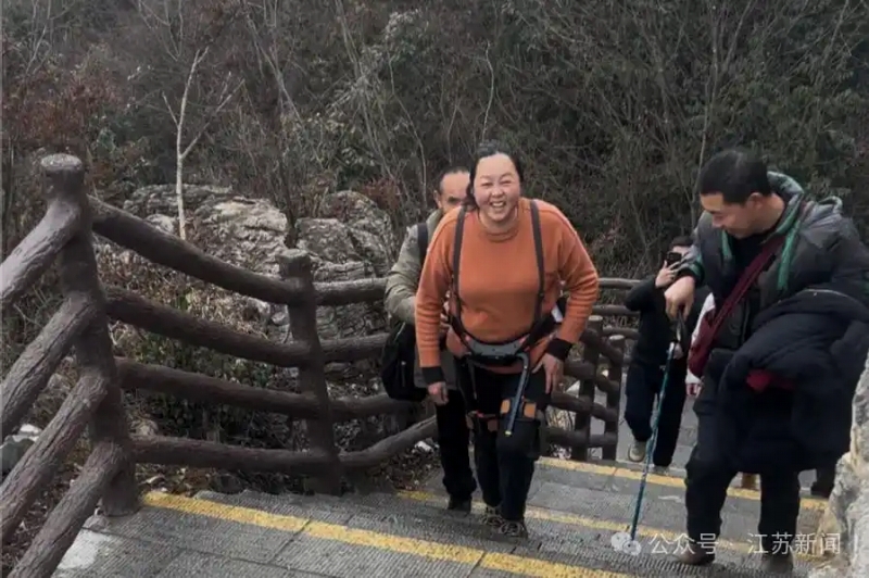 登山アシストロボットを装着して階段を上る観光客（写真提供・取材対応者）。