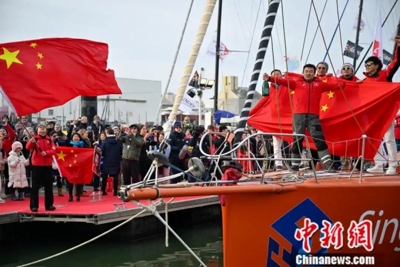 船上で中国の国旗「五星紅旗」を広げる徐京坤さん。（写真提供は取材対象者）