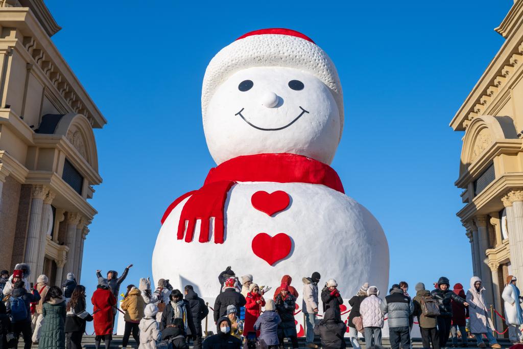 巨大雪だるまをバックにたくさんの見物客が記念撮影を撮る様子（2024年12月17日、撮影・張涛）。