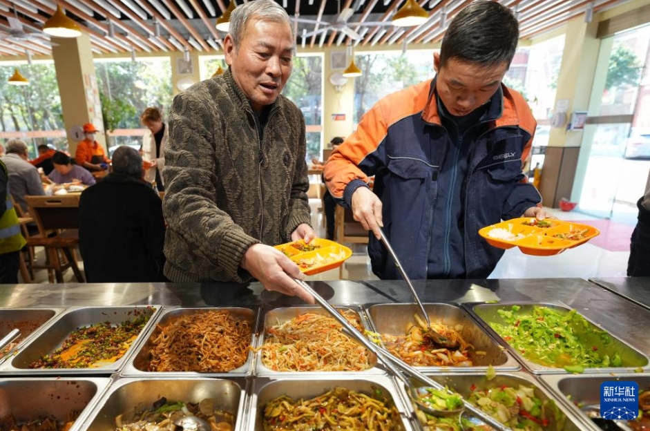 湖南省湘潭市雨湖区和平街道（エリア）にある杉山社区食堂で、料理を取る高齢者（写真左、3月19日撮影・陳澤国）。