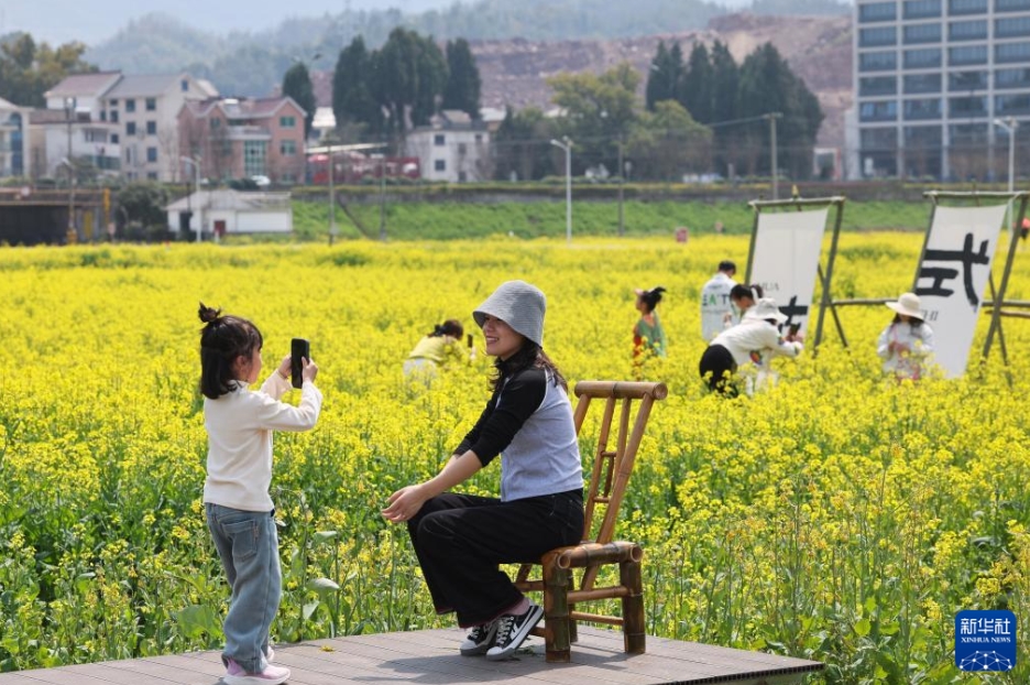 浙江省建徳市更楼街道にある城南城市田園の菜の花畑で写真を撮影する観光客（3月23日撮影・徐昱）。