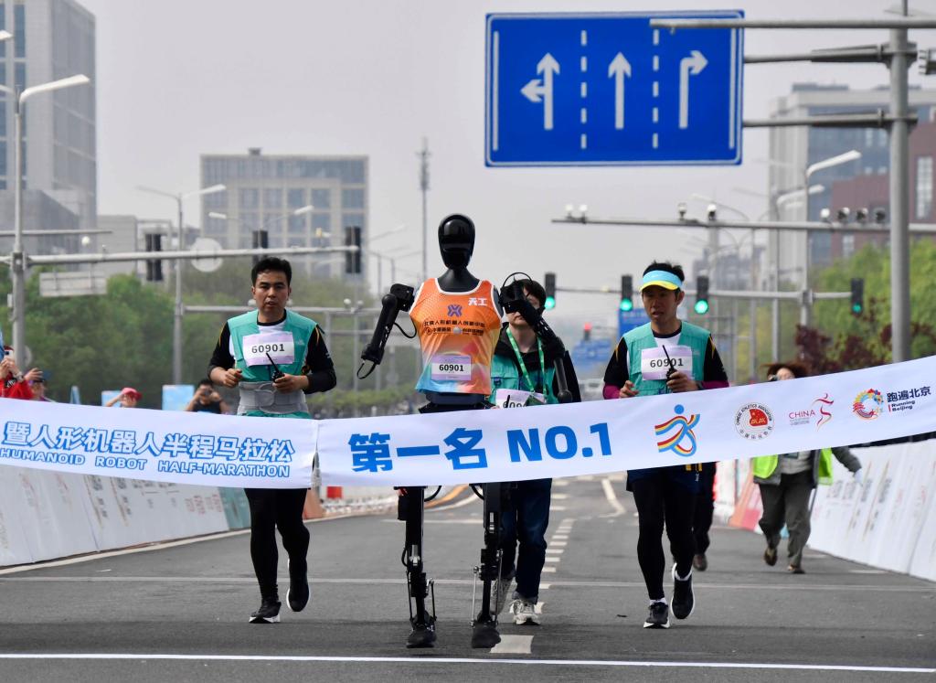 2025北京亦荘ハーフマラソン・人型ロボットハーフマラソンでゴールテープを切る天工チームの選手・天工Ultra（写真左から2番目、4月19日撮影・李欣）。