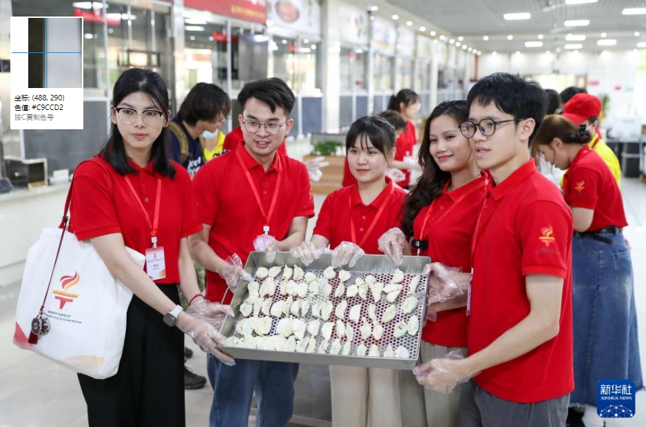 広西師範大学の学食で、自分たちで作った餃子を見せるベトナムの青年（5月19日撮影・李旭倫）。
