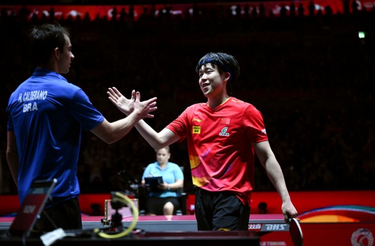 互いに健闘をたたえ合う中国の王楚欽選手（写真右）とブラジルのウーゴ・カルデラノ選手（撮影・賀長山）。
