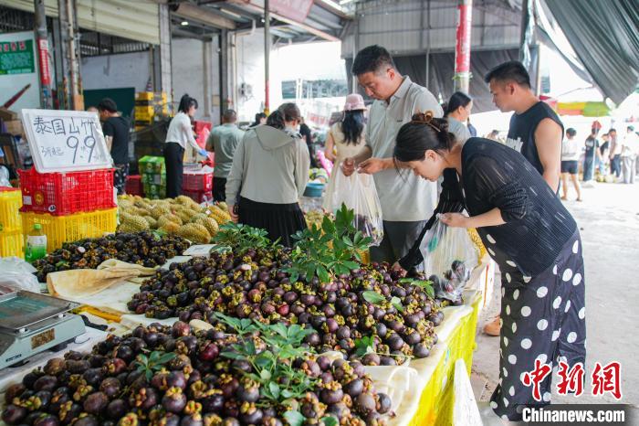 広西海吉星農産品国際物流センターで、タイ産マンゴスチンを購入する買物客（5月28日撮影・陳冠言）。