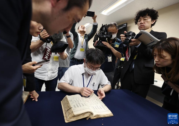 東京の国立公文書館で、中国侵略日本軍細菌戦部隊「登第1644部隊」の留守名簿から、竹上勝利さんの父親・宮下利市さんに関する記録を探す職員（5月14日撮影・賈浩成）。
