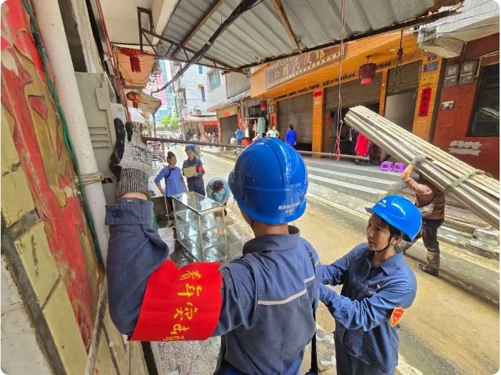 市街地で1軒1軒、壊れた電力メーターを交換する作業員（撮影・謝釋与）。