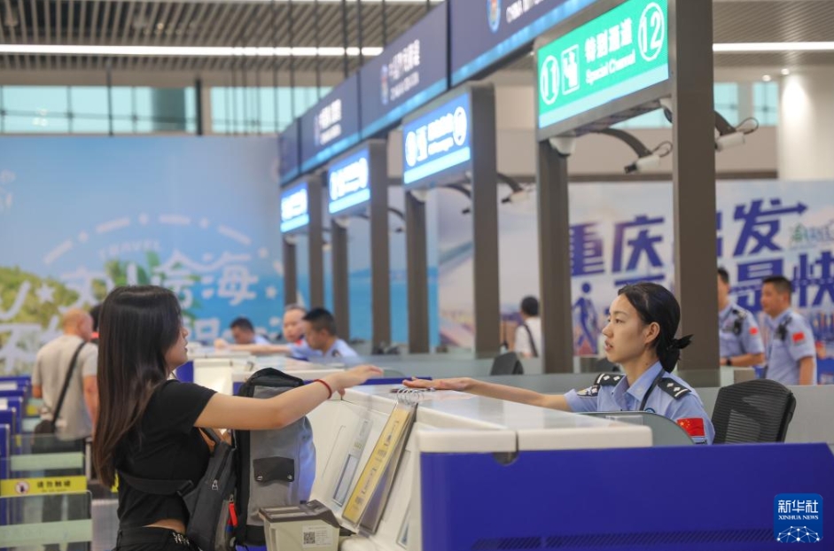 重慶江北国際空港で、旅客の入国審査を行う、重慶出入国検査総ステーションの警官（7月8日撮影・黄偉）。