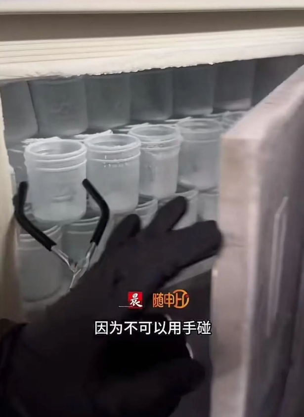 手袋を着用し、アイストングを使ってクライオスタットからコップを取り出す店員 動画のスクリーンショット