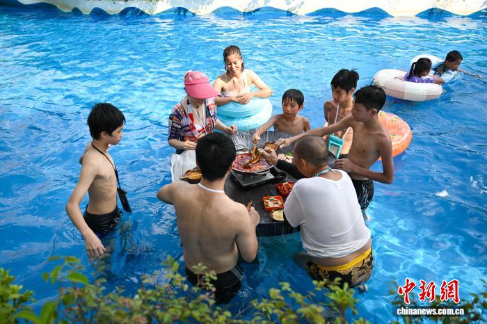 波のプールや水に浸かって火鍋を楽しむ重慶の人々