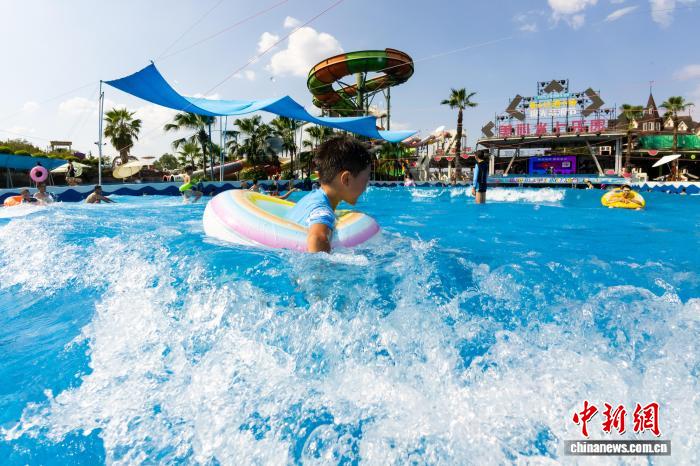 波のプールや水に浸かって火鍋を楽しむ重慶の人々