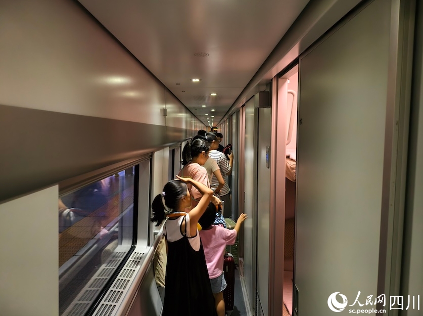 出発前のD966号車内を歩く子供連れの旅客（7月31日撮影・郭瑩）。