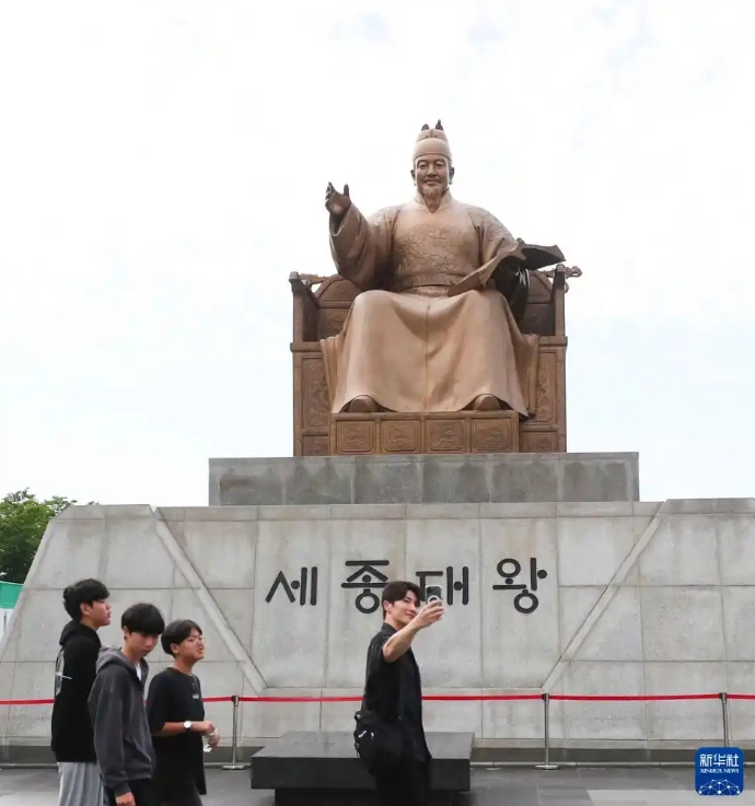 韓国ソウルの光化門（クァンファムン）広場で写真を撮影する男性ら（8月6日撮影・姚琪琳）。