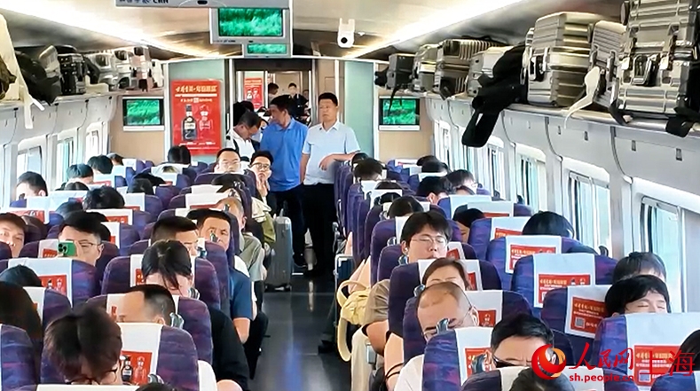 列車の連結部に立つ座席のチケットを買えなかった乗客たち（撮影・顧海民）。