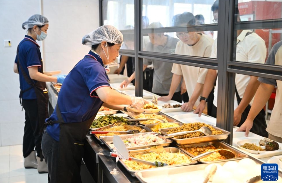 小米行大食堂で料理を器に盛るスタッフ（9月22日撮影・季春鵬）。