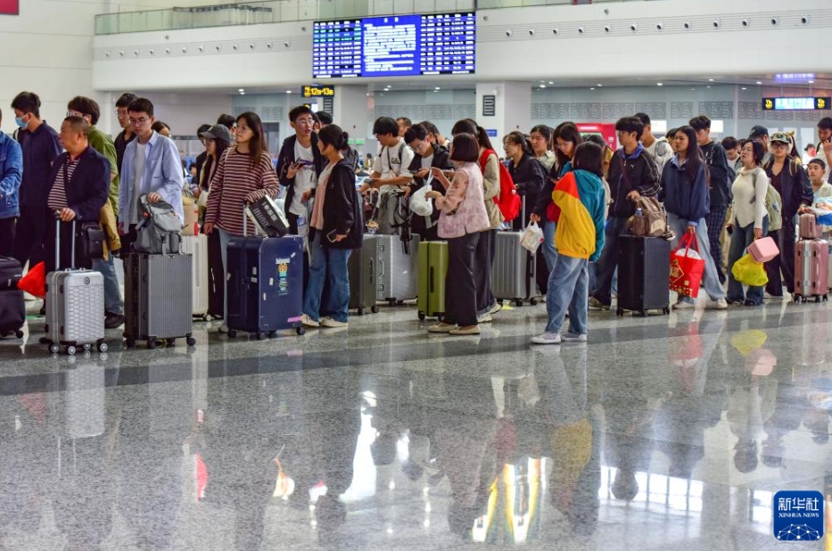 安徽省の阜陽西駅の待合ホールに並んで改札を待つ乗客（10月8日撮影・盧啓建）。