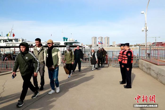 黒河水上輸送国境検査所旅客検査通路から中国に入国するロシアからの観光客（撮影・張鈞凱）。